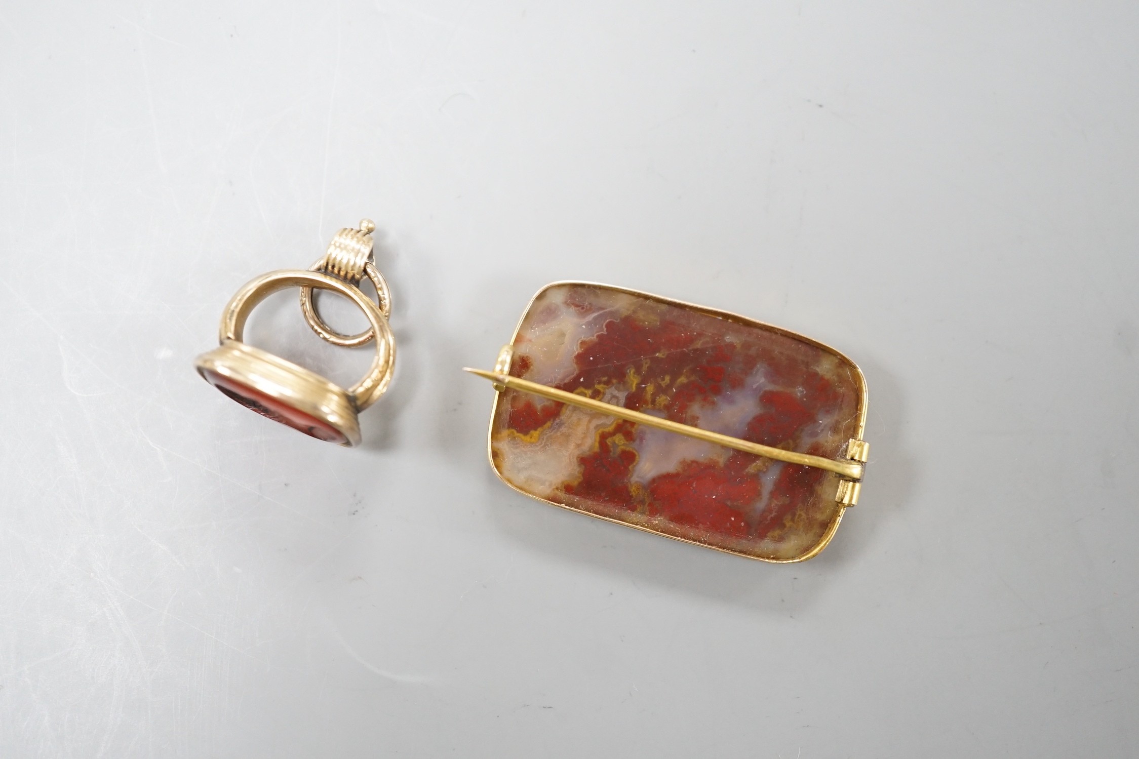 A Victorian yellow metal overlaid seal and and intaglio carnelian set seal, 21mm and a yellow metal and agate set brooch.